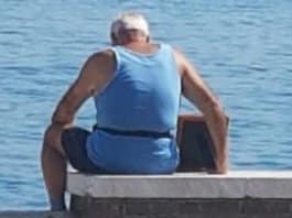 Idoso senta-se com foto de falecida esposa junto à praia todos os dias