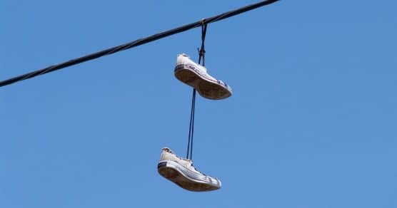 Por que colocam tênis pendurados em fios de energia? Descubra o significado e os motivos para não removê-los