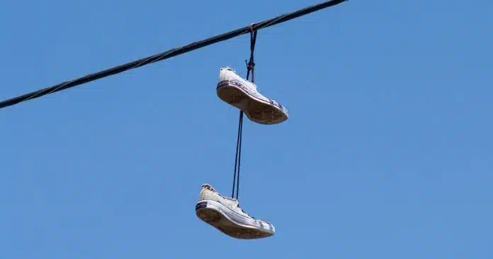 por-que-colocam-tenis-pendurados-em-fios-de-energia-descubra-o-significado-e-os-motivos-para-nao-remove-los Por que colocam tênis pendurados em fios de energia? Descubra o significado e os motivos para não removê-los