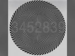 Espiral em preto e cinza com números discretos no centro e preenchimento desfocado nas laterais.